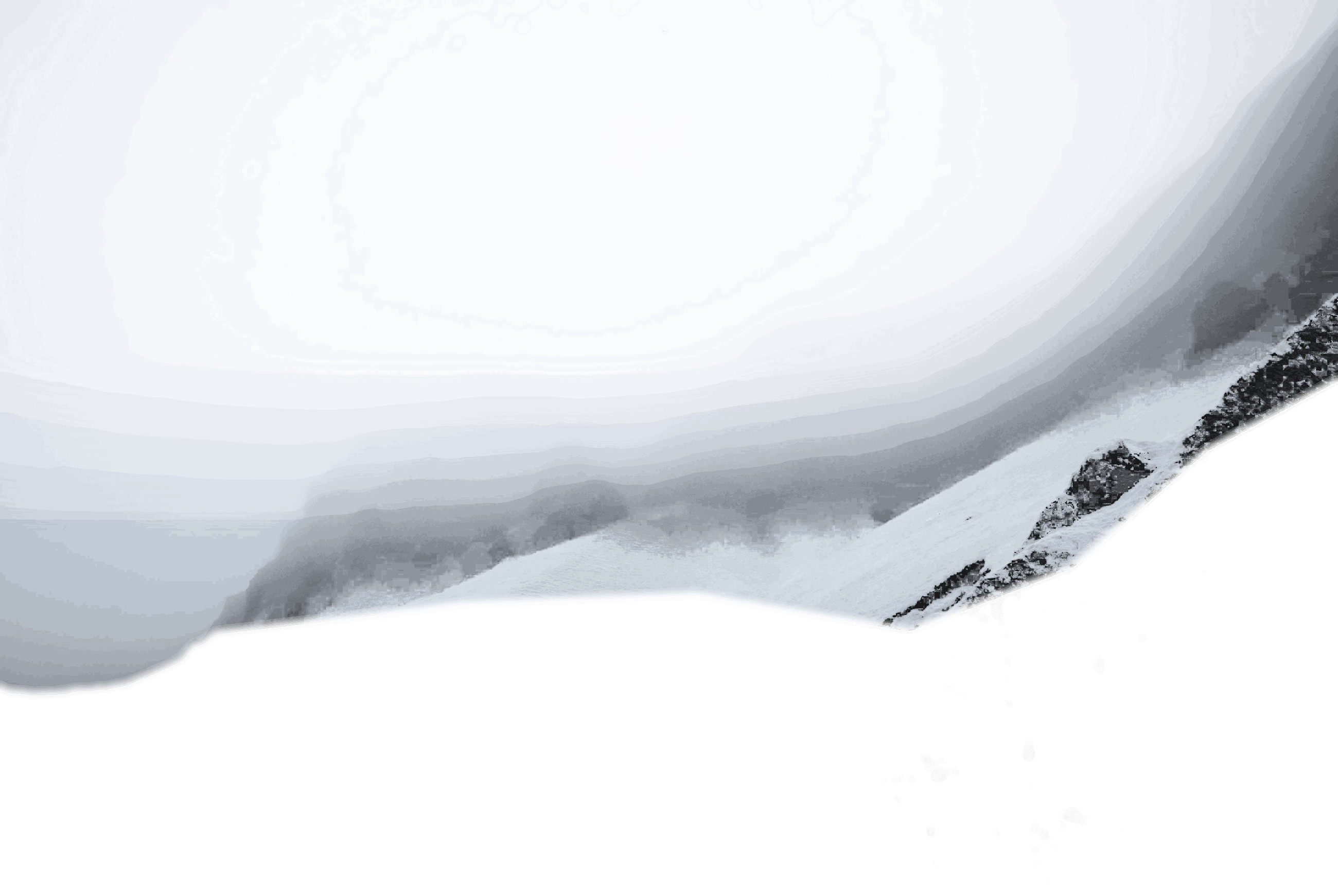 Verschneite Bergkette hinter tiefen Wolken